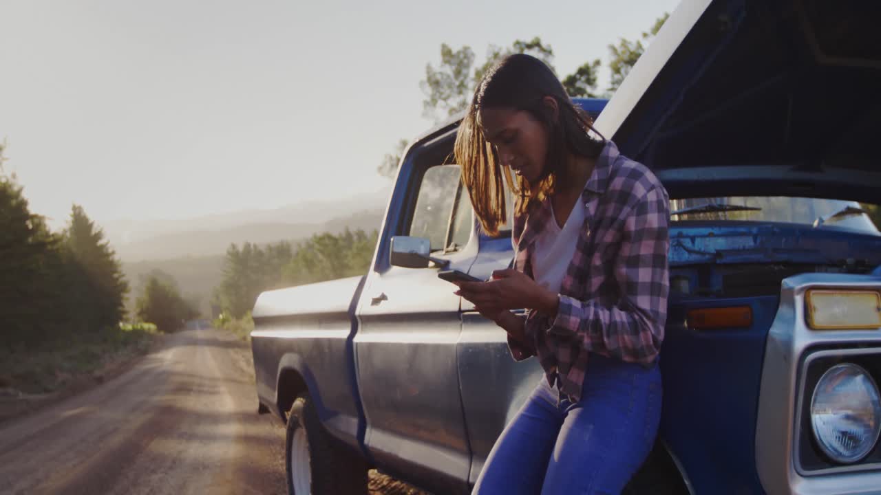 Giovane donna in viaggio on the road su un pick-up
