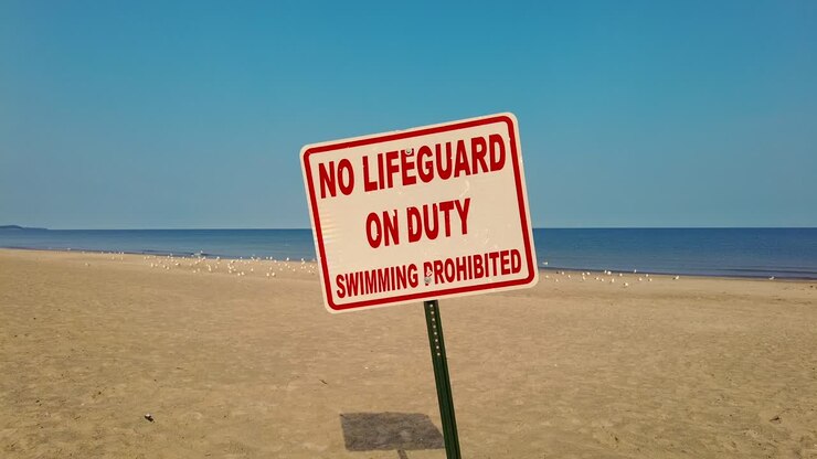 Lenta carrellata su un cartello 'No Bagnino' su una spiaggia nel Lago Ontario, New York