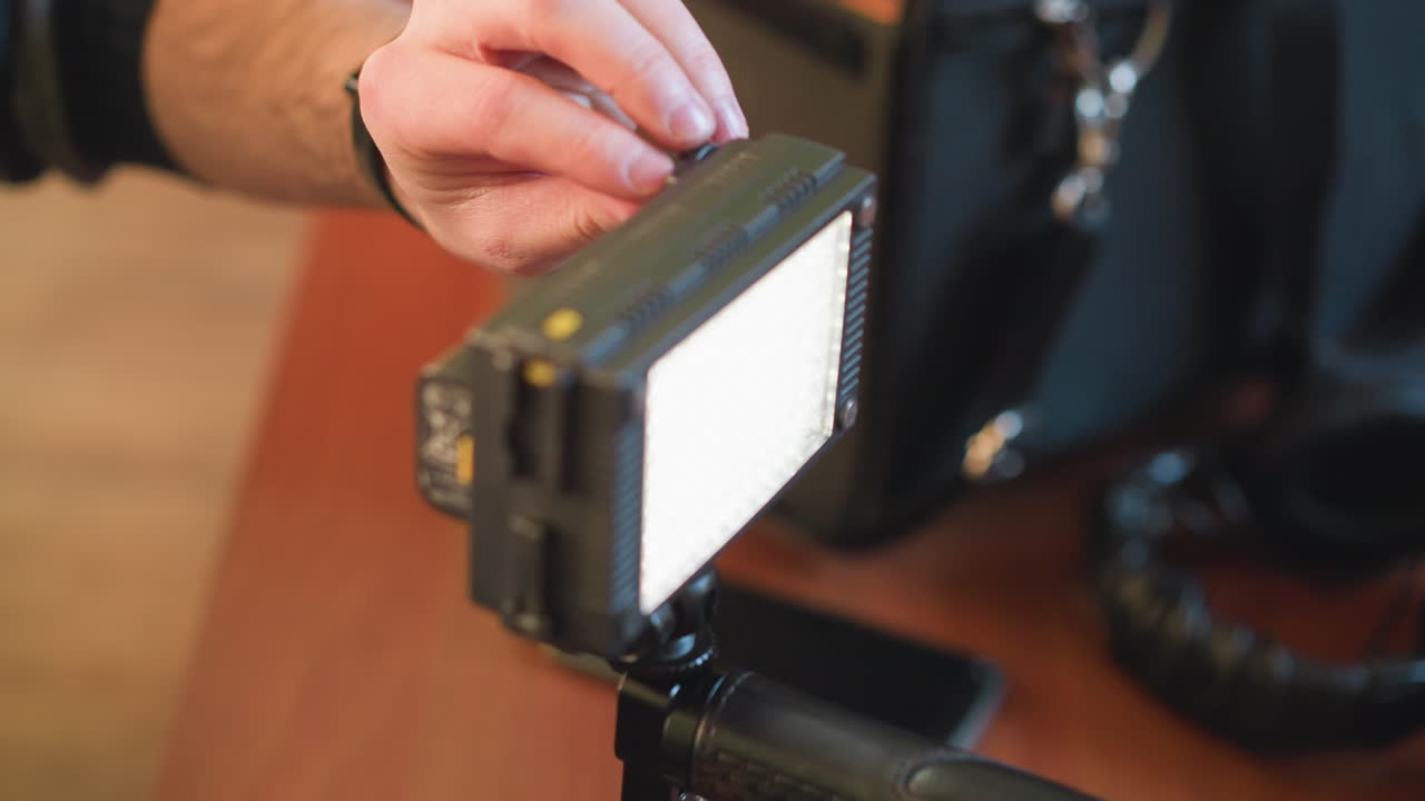 close-up of hands adjusting camera rig, mounting equipment for video production. preparing camera gear and microphone for filming. professional setup for video recording and production
