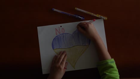 ukrainian flag and a heart in yellow and blue color. child draws a heart on the blackboard