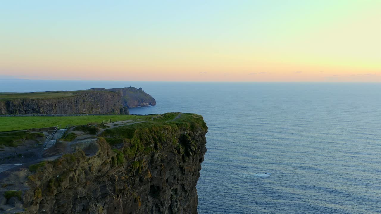 dolly aérea captura la impresionante puesta de sol sobre los acantilados del sur de moher