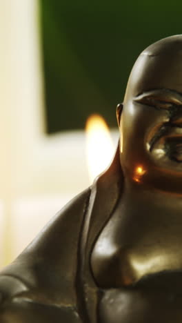 laughing buddha figurine with burning candles