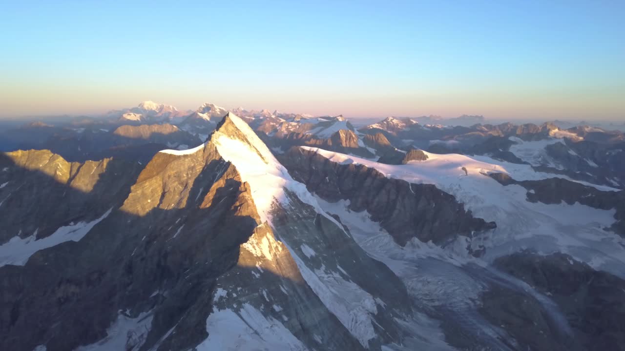 vista aérea amplia y de gran altitud del matterhorn al amanecer con luz dorada en el pico cubierto de nieve