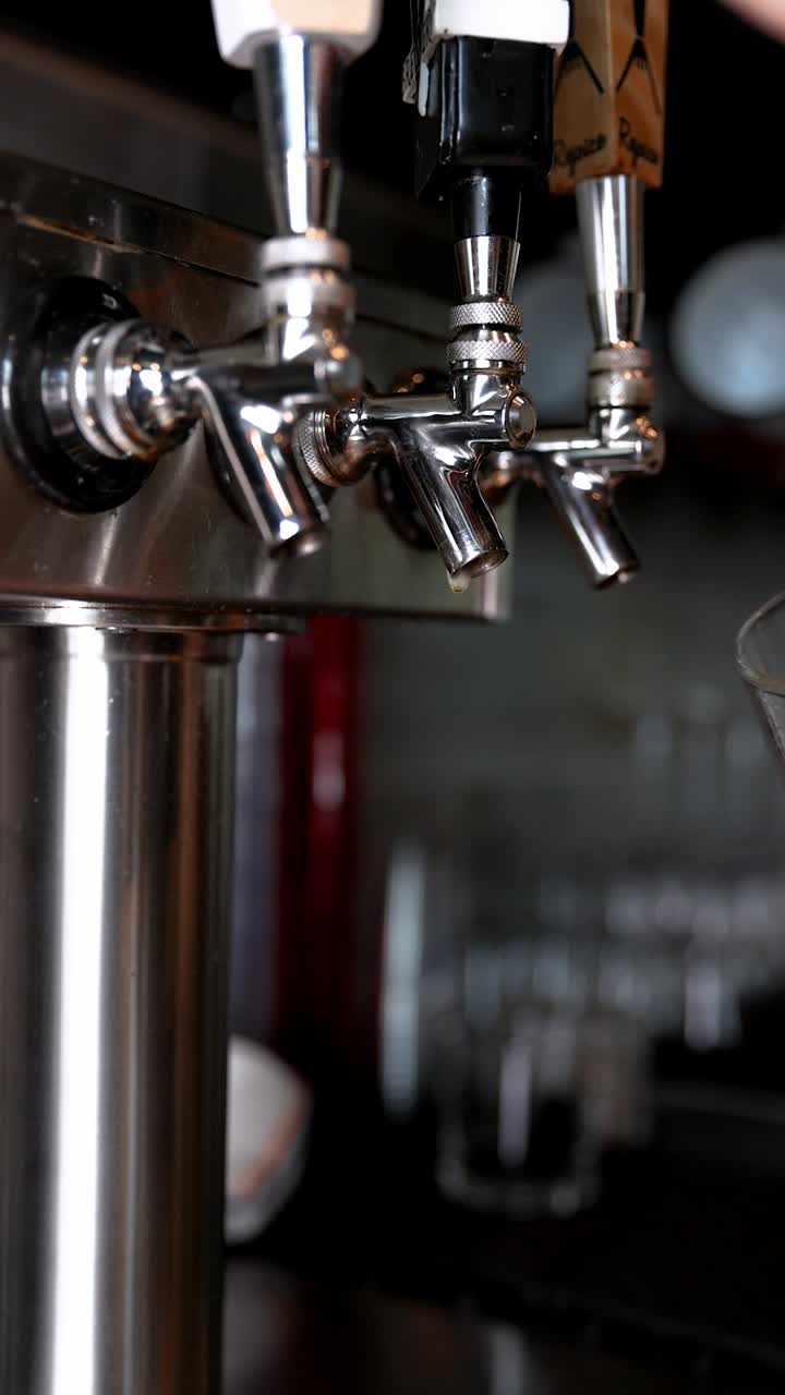 Hand pours golden beer from tap in pub, cozy and relaxing atmosphere