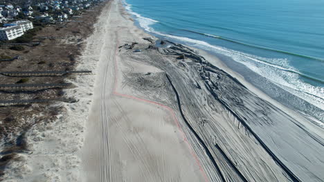 drone shot of beach nourishment, or adding sand or sediment to beaches to combat erosion, can have negative impacts on wildlife and ecosystems, with water coming out of pipe