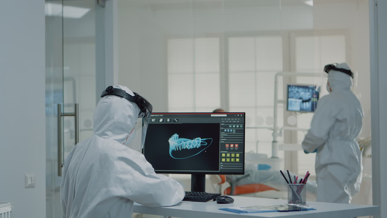 ortodontistas analizando la animación virtual de los dientes en la clínica oral