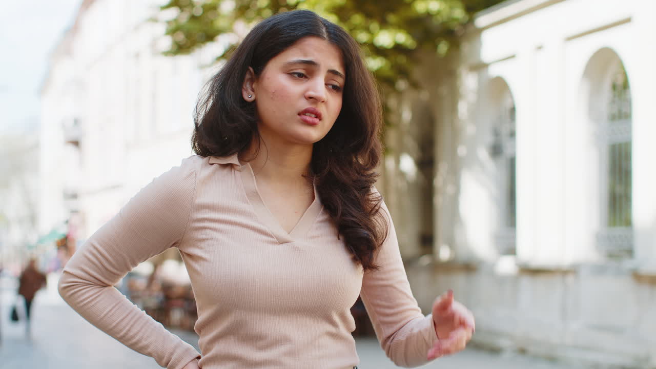 triste infeliz frustrada mujer india caminando sola en la calle de la ciudad sintiéndose mal molesto problema de dolor