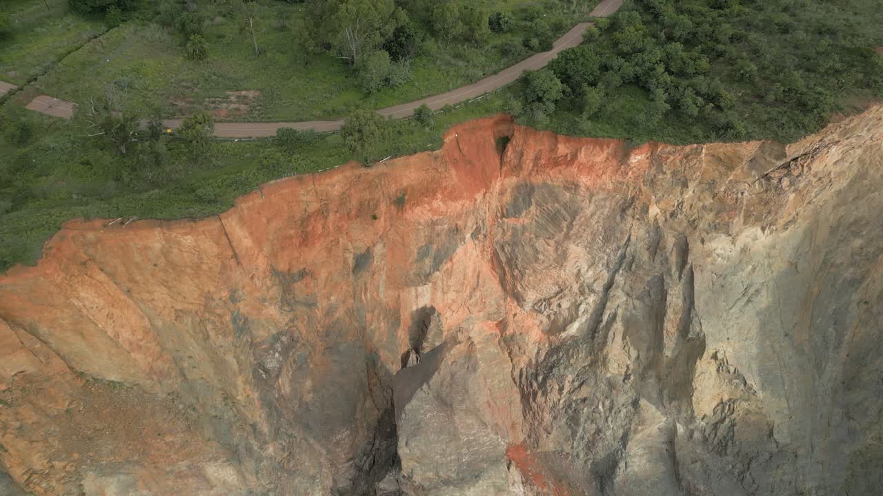 inclinación aérea a la carretera pavimentada cerca del borde del acantilado de roca vertical empinada