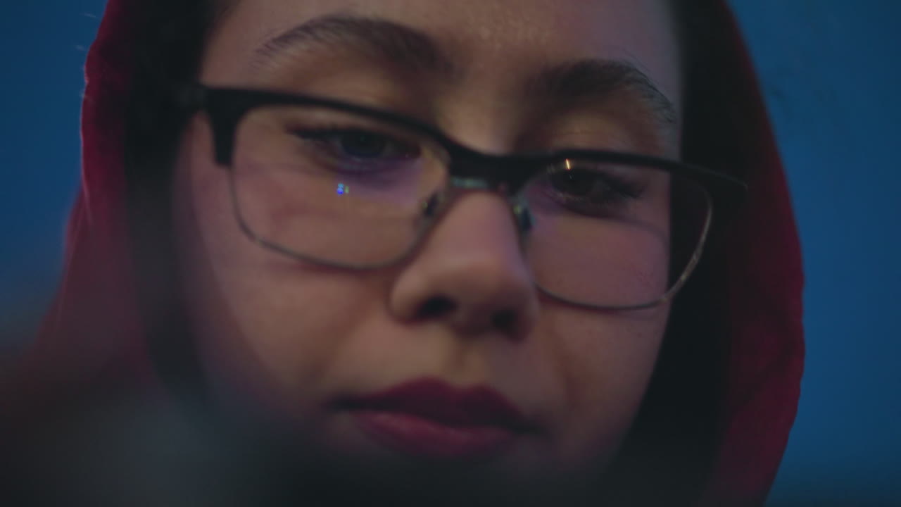 Woman Adjusting Glasses Beneath Sky, Deep Blue Sky Frames Woman With Glasses In Contemplative Pose, Low Angle Shot Showing Woman With Hood And Glasses Under Tranquil Night Sky In Thoughtful Mood