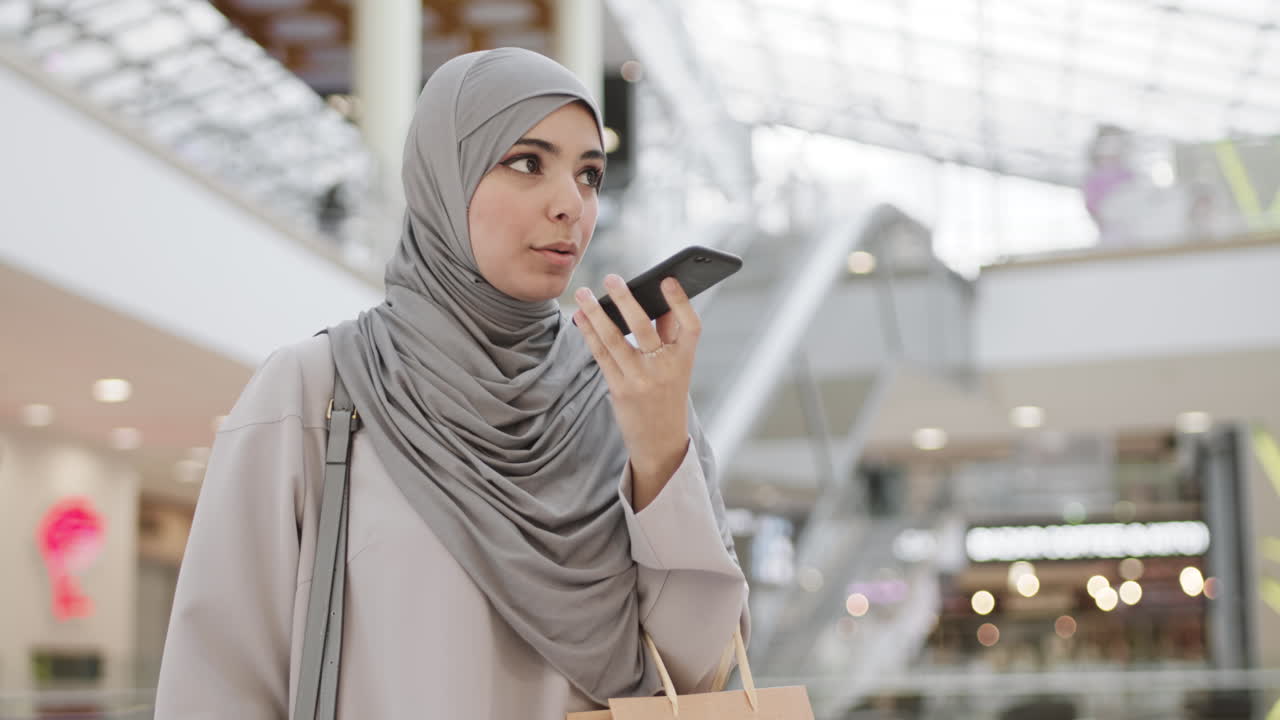 Woman in Hijab Talking on Smartphone in Shopping Mall