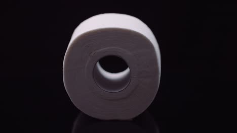 toilet paper isolated on black background rotating.