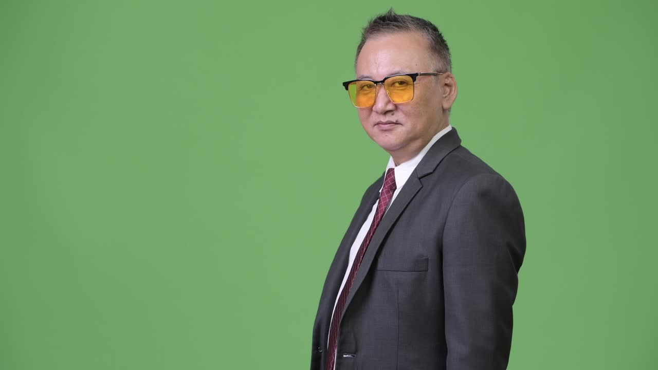 초록색 바탕에 선글라스를 입은 성숙한 일본인 사업가