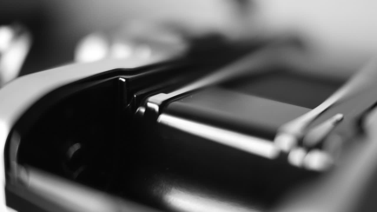 fotografía de cerca de la carga de la película en la cámara en blanco y negro 4k