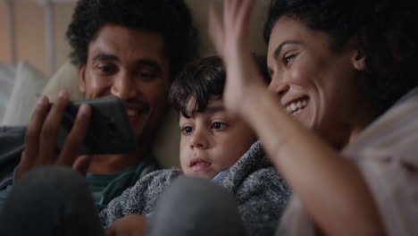 Familia-Feliz-Con-Un-Niño-Pequeño-Video-Chat-Usando-Un-Teléfono-Inteligente-Saludando-La-Pantalla-Disfrutando-De-La-Comunicación-Por-Teléfono-Móvil-En-Casa