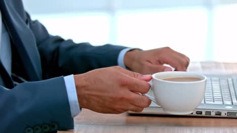 Casual-businessman-using-his-laptop