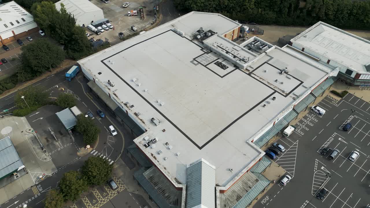 Aerial fly over of an active retail district and Morrison's carpark in Canterbury