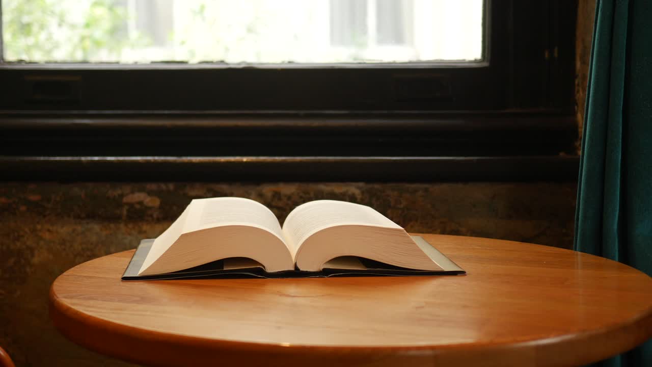 창문 에 있는 나무 테이블 위에 열린 책