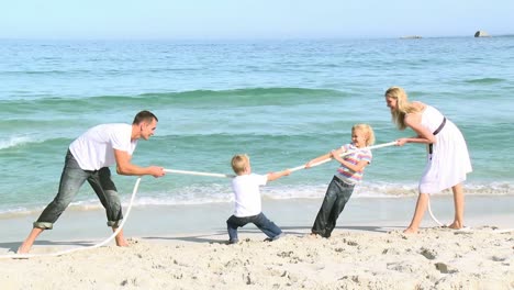 family playing with a string on the beach