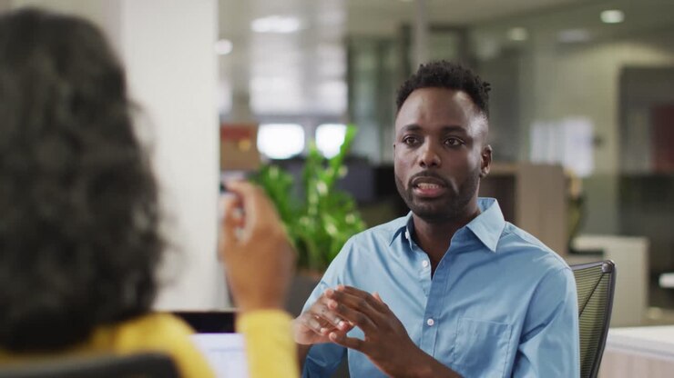 Video di uomo d'affari afroamericano concentrato che parla in ufficio con una collega