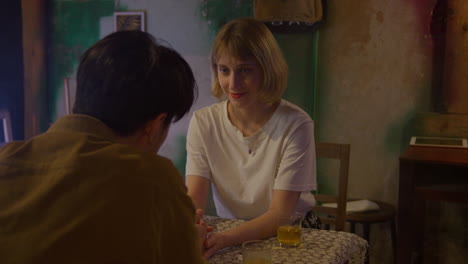 lovers sitting at cafe bar restaurant drinking cocktail while talking on their first date