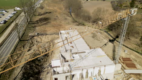 vuelo aéreo de drones sobre una grúa y un sitio de construcción de arena en el campo durante el día soleado