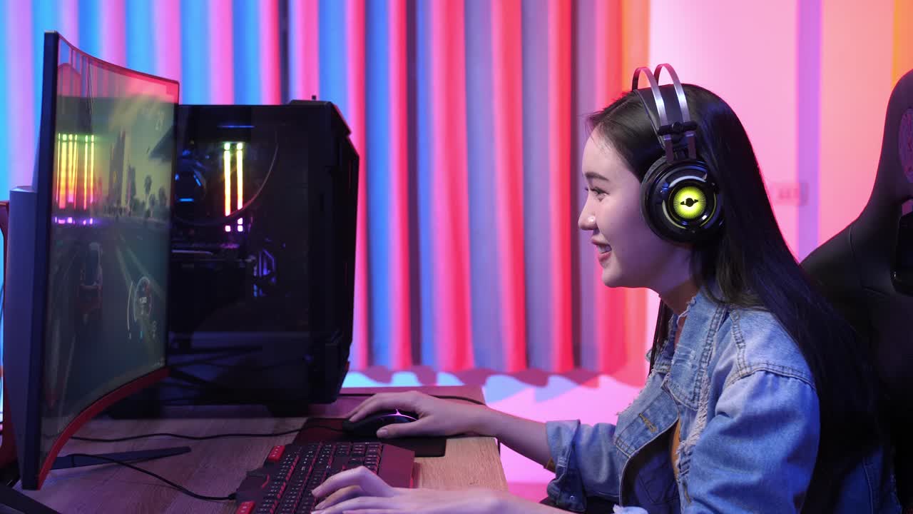 Ragazza asiatica entusiasta che gioca a un videogioco al computer
