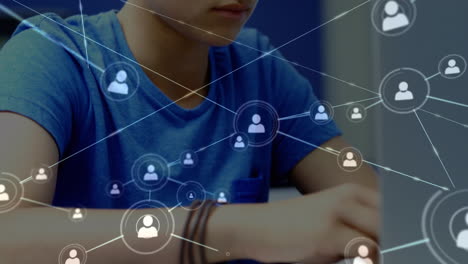 red de iconos de perfiles contra un niño caucásico que usa computadora portátil en la escuela primaria