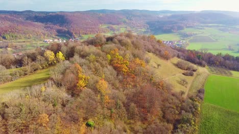 Aerial-view-of-fall-foliage-of-Walberla-which-is-part-of-the-Veldenstein-Forest-in-Upper-Franconian-Switzerland,-Germany