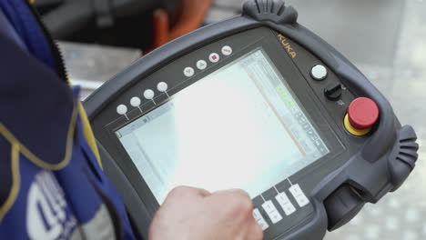 operator interacting with industrial robot control panel