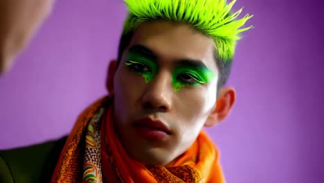 hombre elegante con maquillaje y cabello vibrante