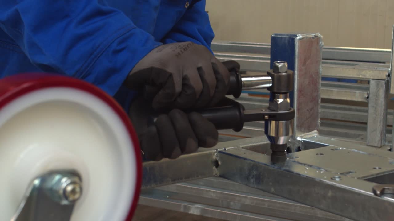 Worker Assembling Metal Frame with Wrench