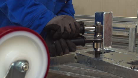 worker assembling metal frame with wrench