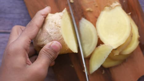 cortar el jengibre con un cuchillo en la tabla de cortar