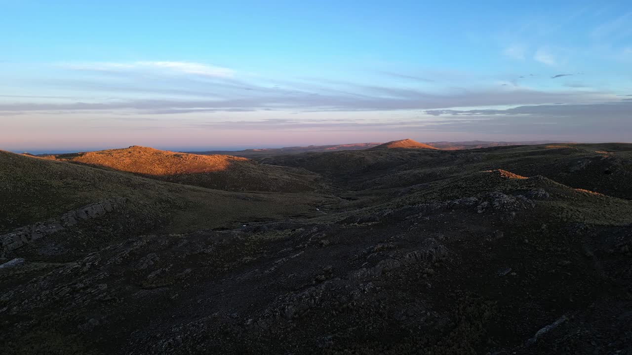 drone disparado por encima de los picos de las montañas, iluminado por las últimas luces de la puesta de sol