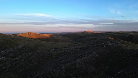 drone shot above the peaks of the mountains, illuminated by the last lights of sunset