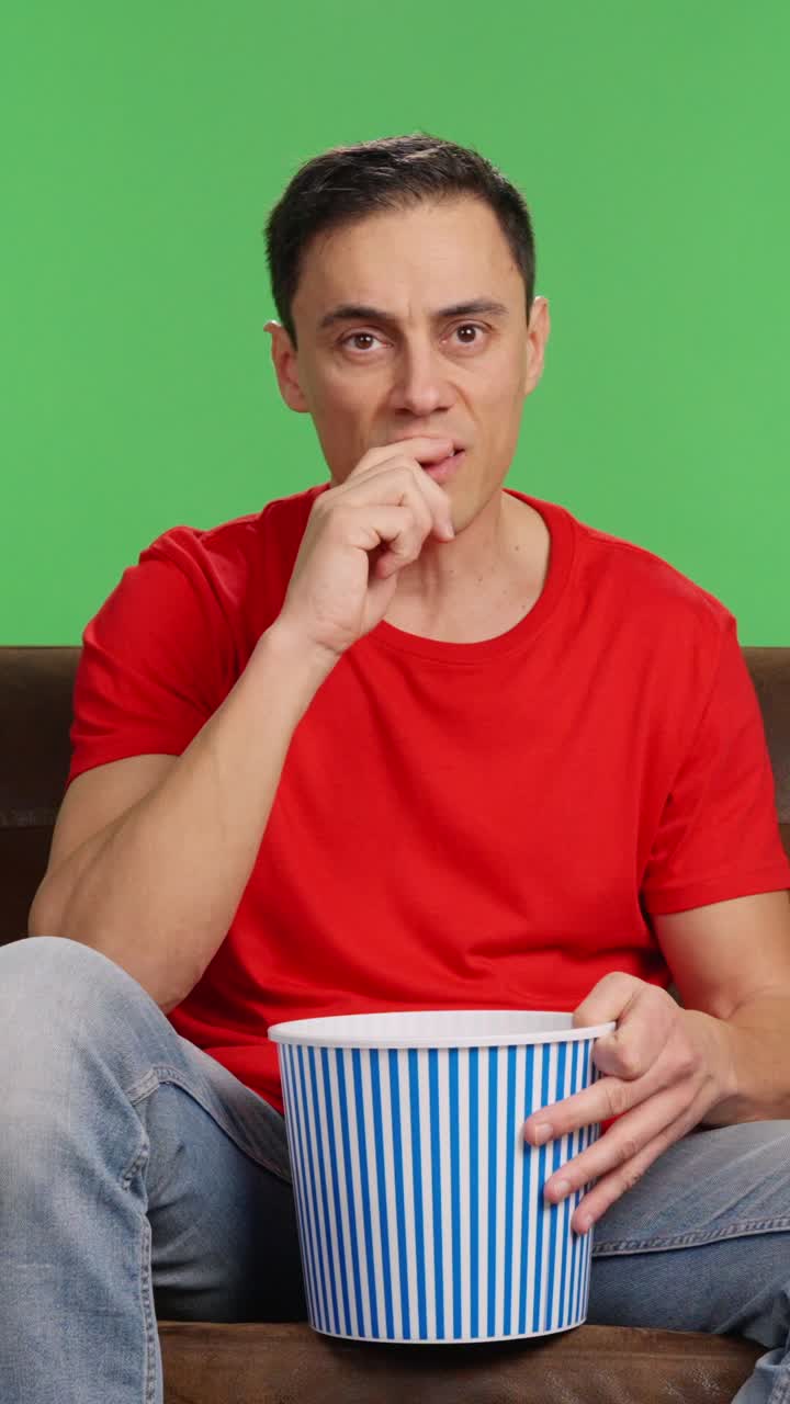 Man watching scary movie on chroma throws popcorn in fear