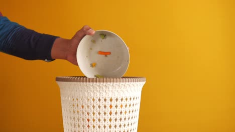 throwing away vegetable scraps into compost bin