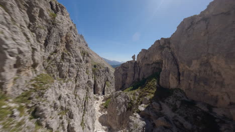 dron volando entre rocas de montaña con meseta en el fondo, dolomitas, montañas italianas