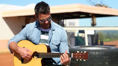 man playing guitar while sitting on car 4k