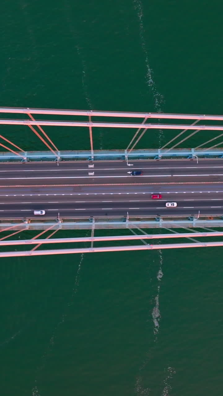 Speed motorways on the Whitestone bridge in New York. Flying high over the bridge construction at the backdrop of turquoise water of river. Vertical video
