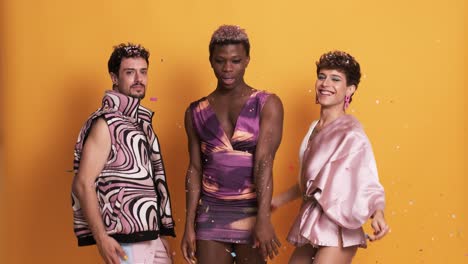 three multiethnic trans men throwing confetti and dancing