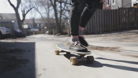 a person rides along the pavement on a longboard