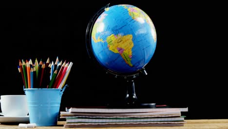 globe and school supplies on table