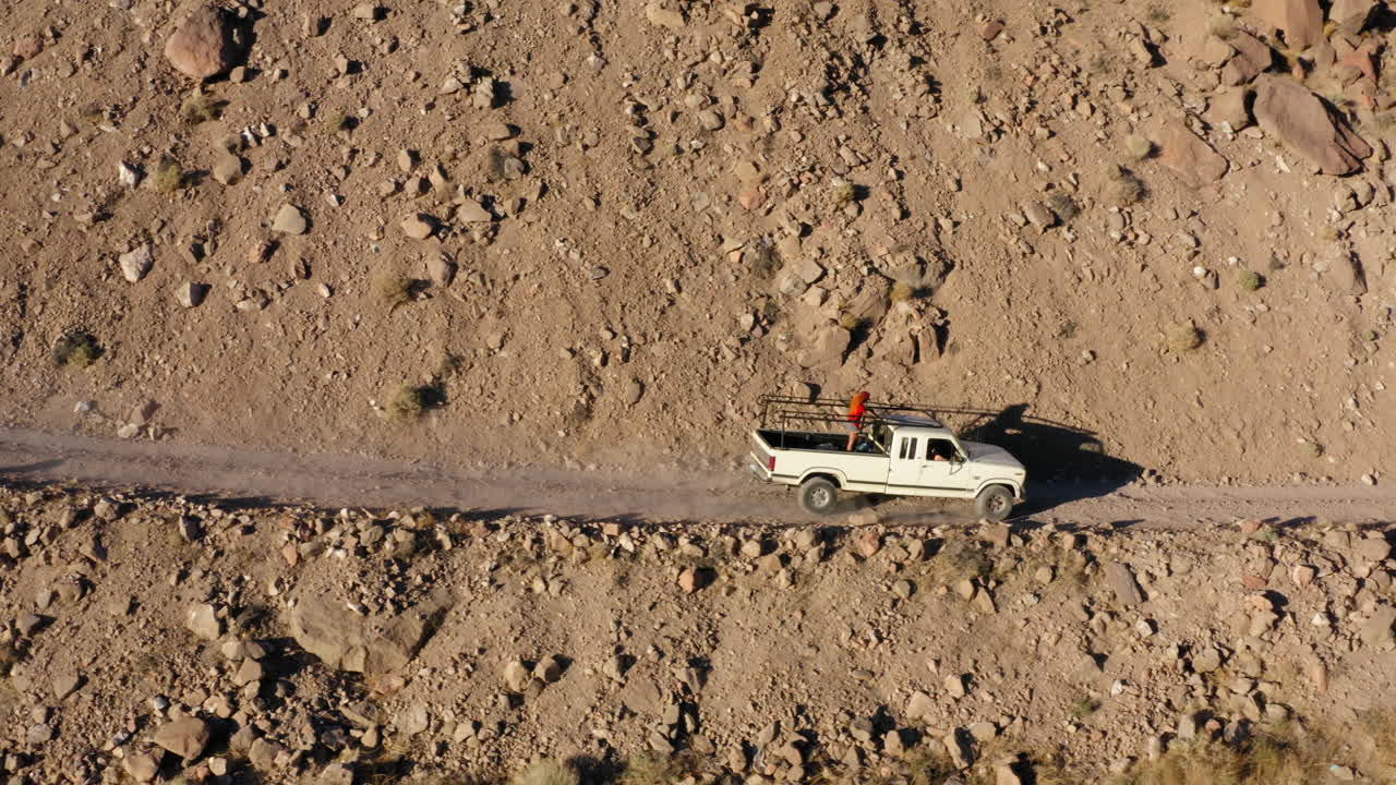 산길에서 운전하고 캘리포니아 주 비숍의 고속도로로 내려가는 자동차의 항공 영상 측면