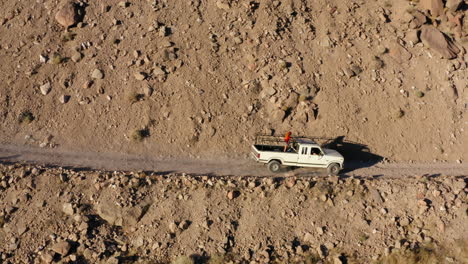 vista lateral de imágenes aéreas de un automóvil que conduce por una carretera de montaña y baja a una autopista en bishop, ca