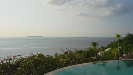 tropical island sunset with boat driving in the distance