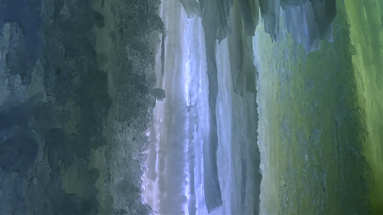 Inside the Eben Ice Caves in Michigan, close up view of thick vertical ice walls appear in striking blue and yellow hues