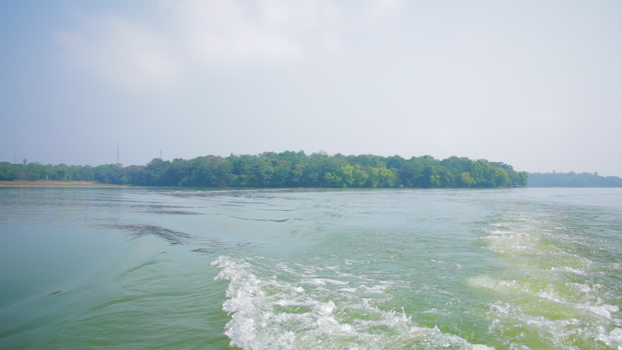 Serene Kabini river with a lush green island in the background, viewed from a moving boat in India