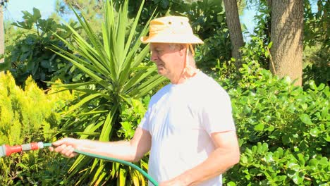 hombre regando su jardín