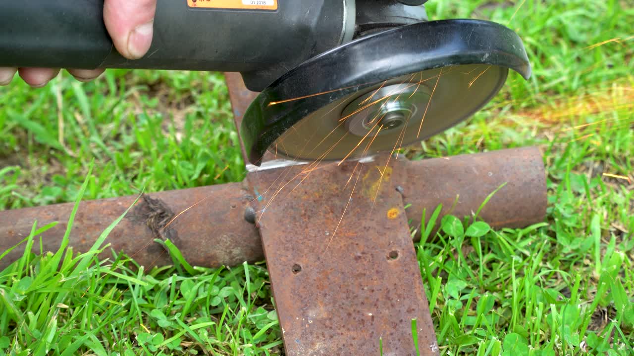 손 도구로 잔디에 금속을 자르는 것은 철에서 날아오는 불꽃입니다.
